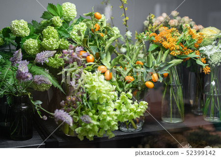 Flower shop concept. Glass vases with different colors on the shelves of the refrigerator showcases Flower shop concept. Glass vases with different colors on the shelves of the refrigerator showcases 52399142