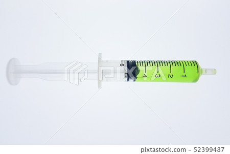 Syringe containing a green substance inside is pla Syringe containing a green substance inside is pla 52399487