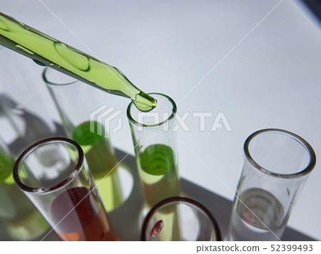 Pipettes take samples to a test tube containing ch 52399493