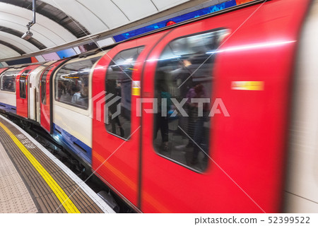 London tube platform edge. Painted warning on the floor. Train passing by. London tube platform edge. Painted warning on the floor. Train passing by. 52399522