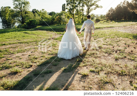 lovers is running with hold hands in forest 52406216