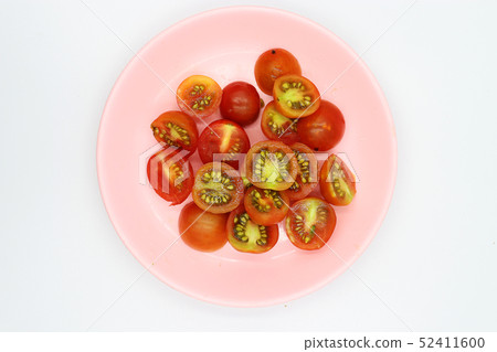 shopped tomatoes in pink dish on white background. 52411600