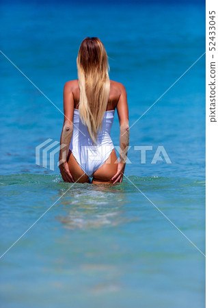 Sexy woman in white bikini walking at Karon beach, 52433045
