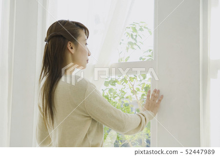 Woman opening curtain 52447989