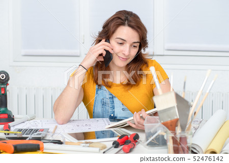 pretty young woman doing DIY talking on phone 52476142