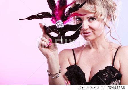 Woman middle aged holds carnival mask. 52495588