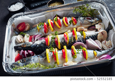 three raw mackerel in a baking pan, close up 52552185