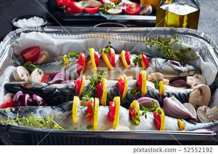 three raw mackerel in a baking pan, close up three raw mackerel in a baking pan, close up 52552192