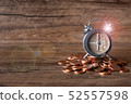 Alarm clock at six o' clock on pill of gold coins  52557598