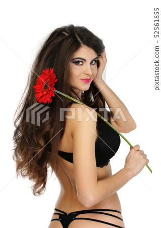Portrait of beautiful brunette girl in black underwear with red gerbera on shoulder. Portrait of beautiful brunette girl in black underwear with red gerbera on shoulder. 52561855