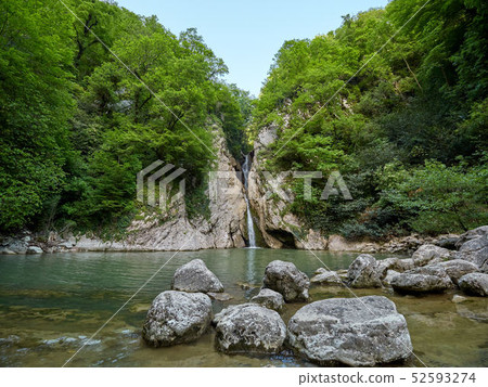 A high waterfall falls from a cliff A high waterfall falls from a cliff 52593274