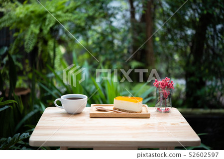 Passion fruit cheesecake and hot coffee cup on 52602597