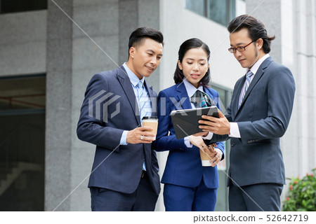 Business people using tablet pc outdoors Business people using tablet pc outdoors 52642719