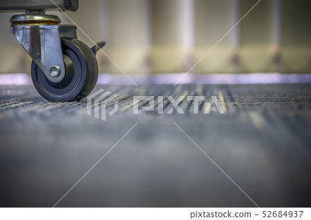 Small black rubber wheels on the carpet. 52684937