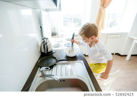 funny European little boy chef dancing,Happy weekend, boy wants to make pancakes, but the frying pan funny European little boy chef dancing,Happy weekend, boy wants to make pancakes, but the frying pan 52692425