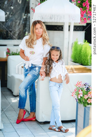 Fashion family concept - stylish mother and child wear. A portrait of a happy family: a young 52717467