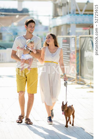 young stylish hipster couple in love walking playing dog puppy in tropical beach, white sand, cool young stylish hipster couple in love walking playing dog puppy in tropical beach, white sand, cool 52725615