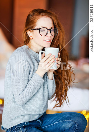 Young and sexy woman on the bed in cosy room with lot of light bulbs on background 52726911