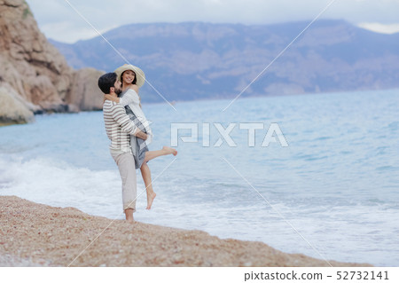 A Man and woman in love enjoying together near sea, running by the beach, laughing, kissing A Man and woman in love enjoying together near sea, running by the beach, laughing, kissing 52732141