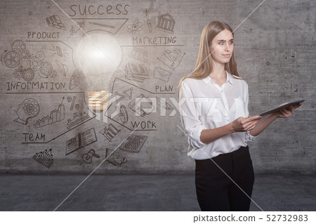Beautiful business woman against a concrete wall with sketch drawn on it and bright lightbulb Beautiful business woman against a concrete wall with sketch drawn on it and bright lightbulb 52732983