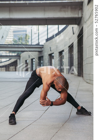 Young muscular sportsman doing stretching before 52765902