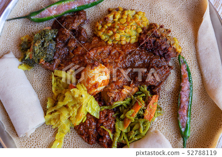 Injera with an assortment of toppings 52788119