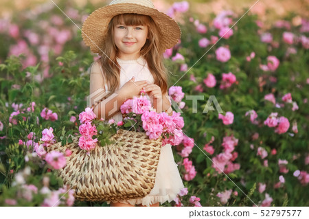 A little girl with beautiful long blond hair, dressed in a light dress and a wreath of real flowers A little girl with beautiful long blond hair, dressed in a light dress and a wreath of real flowers 52797577