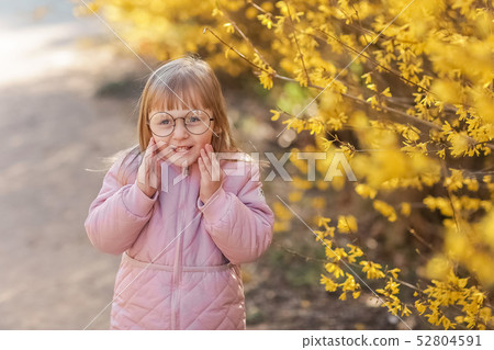 Stylish child girl 5-6 year old wearing trendy pink coat in autumn park. Looking at camera. Autumn Stylish child girl 5-6 year old wearing trendy pink coat in autumn park. Looking at camera. Autumn 52804591