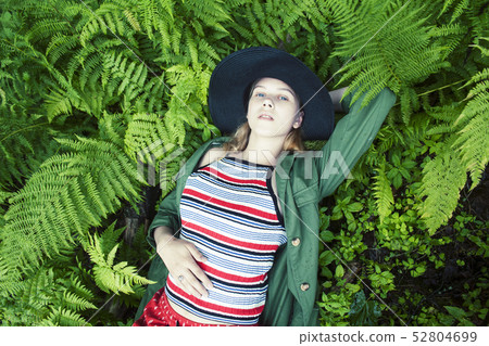 Pretty young blond girl hipster in hat among fern, vacation in green forest, lifestyle people 52804699