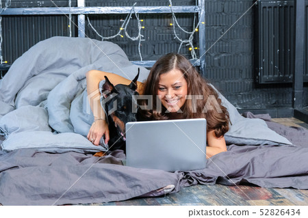 Woman in bed with big dog 52826434