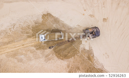 Tod down view of excavator pours sand into the truck. On the construction site. 52916263