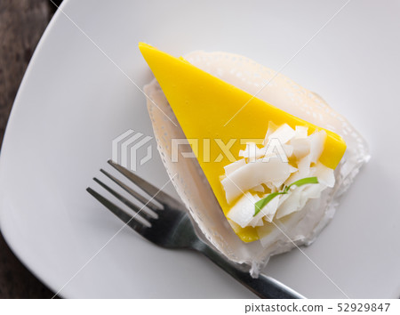 Top view mango cake and coconut topping on wood Top view mango cake and coconut topping on wood 52929847