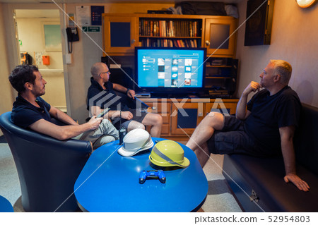 Happy team of ship officers watch TV onboard of vessel Happy team of ship officers watch TV onboard of vessel 52954803