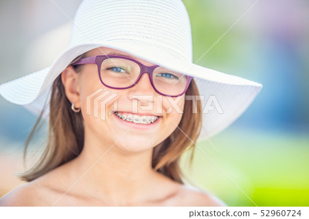 Happy smiling girl with dental braces and glasses. Happy smiling girl with dental braces and glasses. 52960724