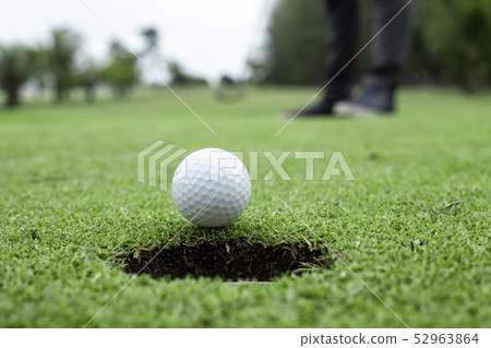 Golfer putting golf ball approach to the golf hole Golfer putting golf ball approach to the golf hole 52963864
