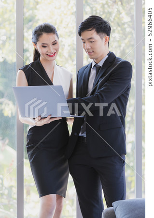Asian business people standing in office.. Asian business people standing in office.. 52966405