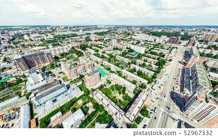 Aerial city view with crossroads and roads, houses, buildings, parks and parking lots. Sunny summer Aerial city view with crossroads and roads, houses, buildings, parks and parking lots. Sunny summer 52967332