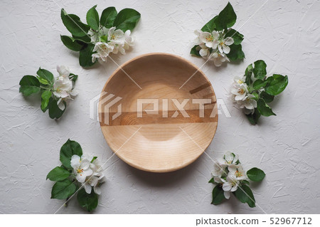 Wooden plate with flowers on a grey background. Wooden plate with flowers on a grey background. 52967712