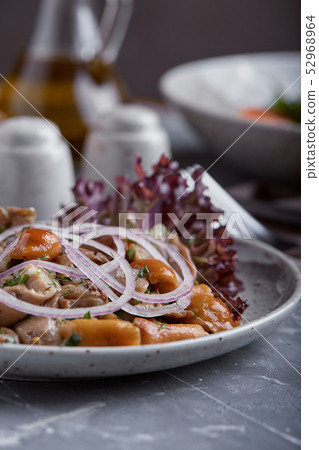 marinated mushrooms and onions in a plate on a grey background marinated mushrooms and onions in a plate on a grey background 52968964