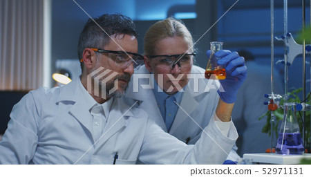 Scientists examining various liquids Scientists examining various liquids 52971131