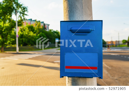 Blue mailbox on the grey post 52971905