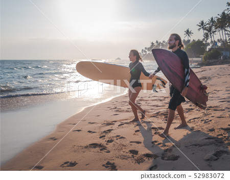 Young beautiful couple of friends with surfboards in their hands, sports, active lifestyle 52983072