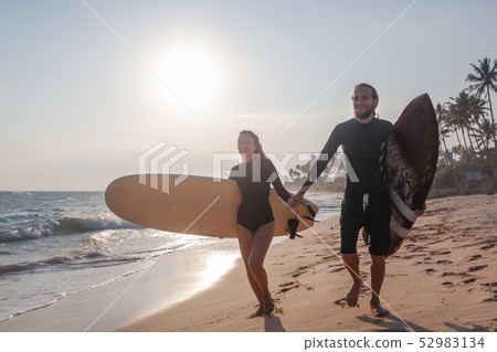 Young beautiful couple of friends with surfboards in their hands, sports, active lifestyle 52983134