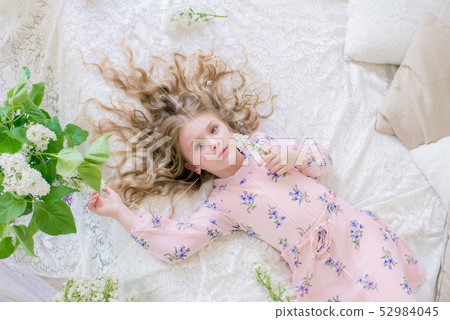 little girl with blond hair with lilac flowers 52984045