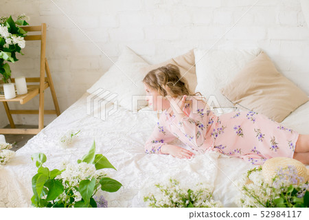 little girl with blond hair with lilac flowers 52984117
