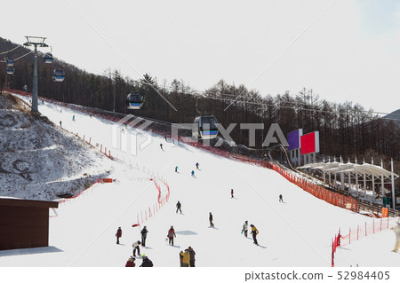 People who enjoy skiing and snowboarding on the slopes People who enjoy skiing and snowboarding on the slopes 52984405