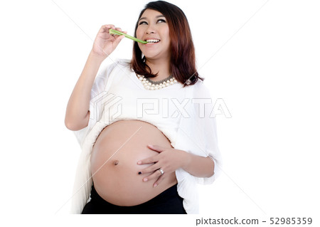 Smiling pregnant woman eating celery 52985359