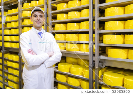 Portrait of inspector standing in production department of dairy factory and take view of redy 52985800