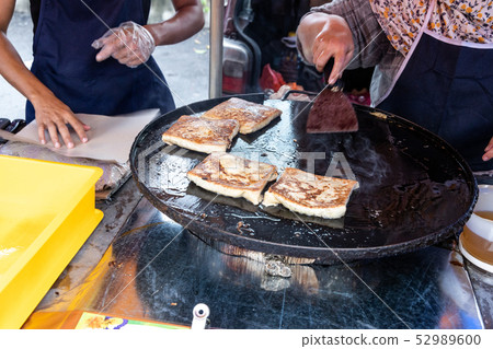 Seller preparing murtabak at street stall Seller preparing murtabak at street stall 52989600