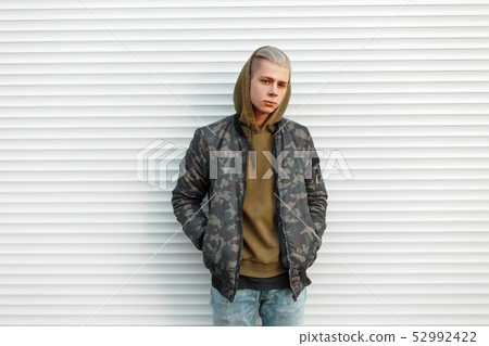 Handsome young man in a trendy military jacket Handsome young man in a trendy military jacket 52992422